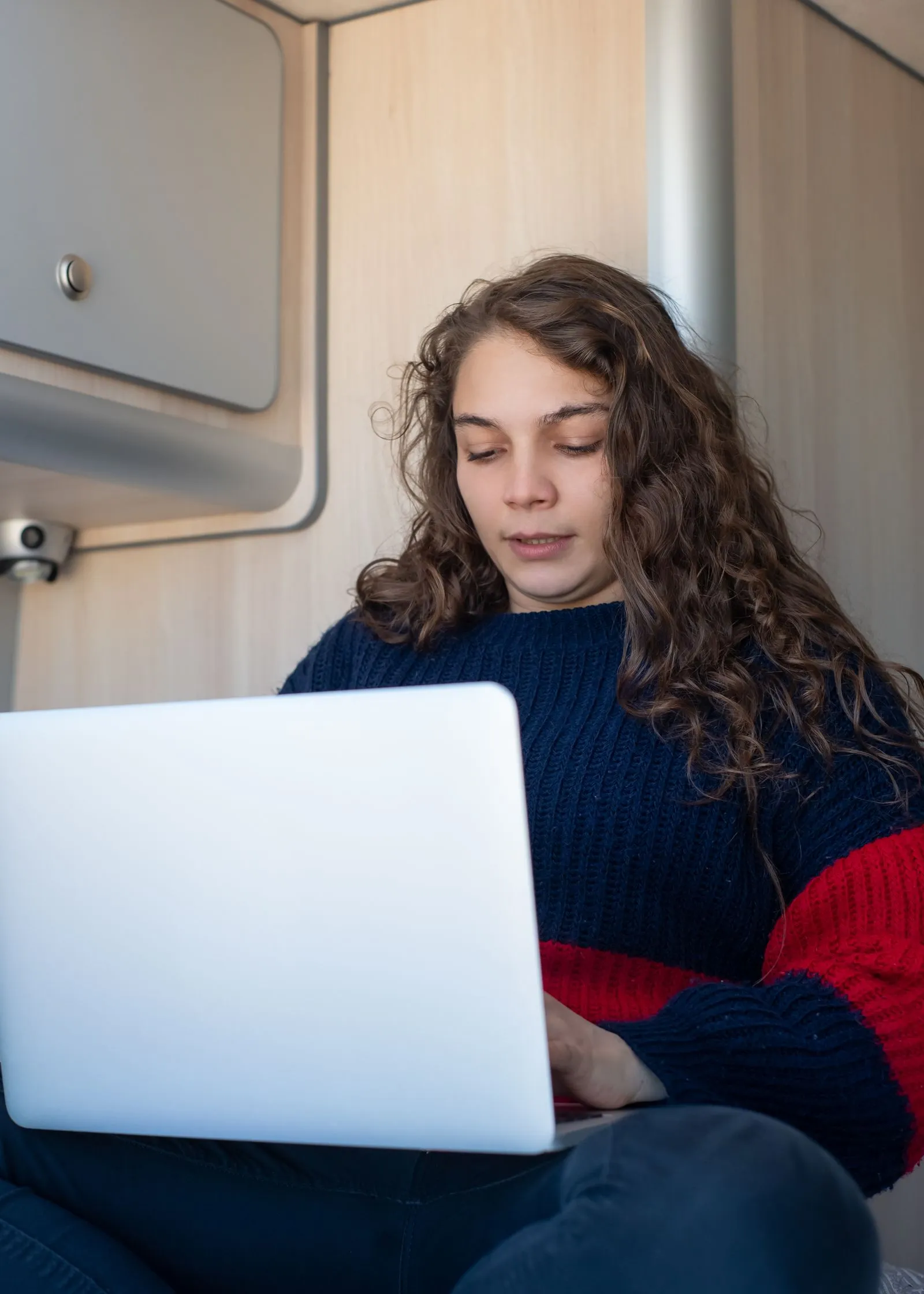 A person working on a laptop inside a campervan