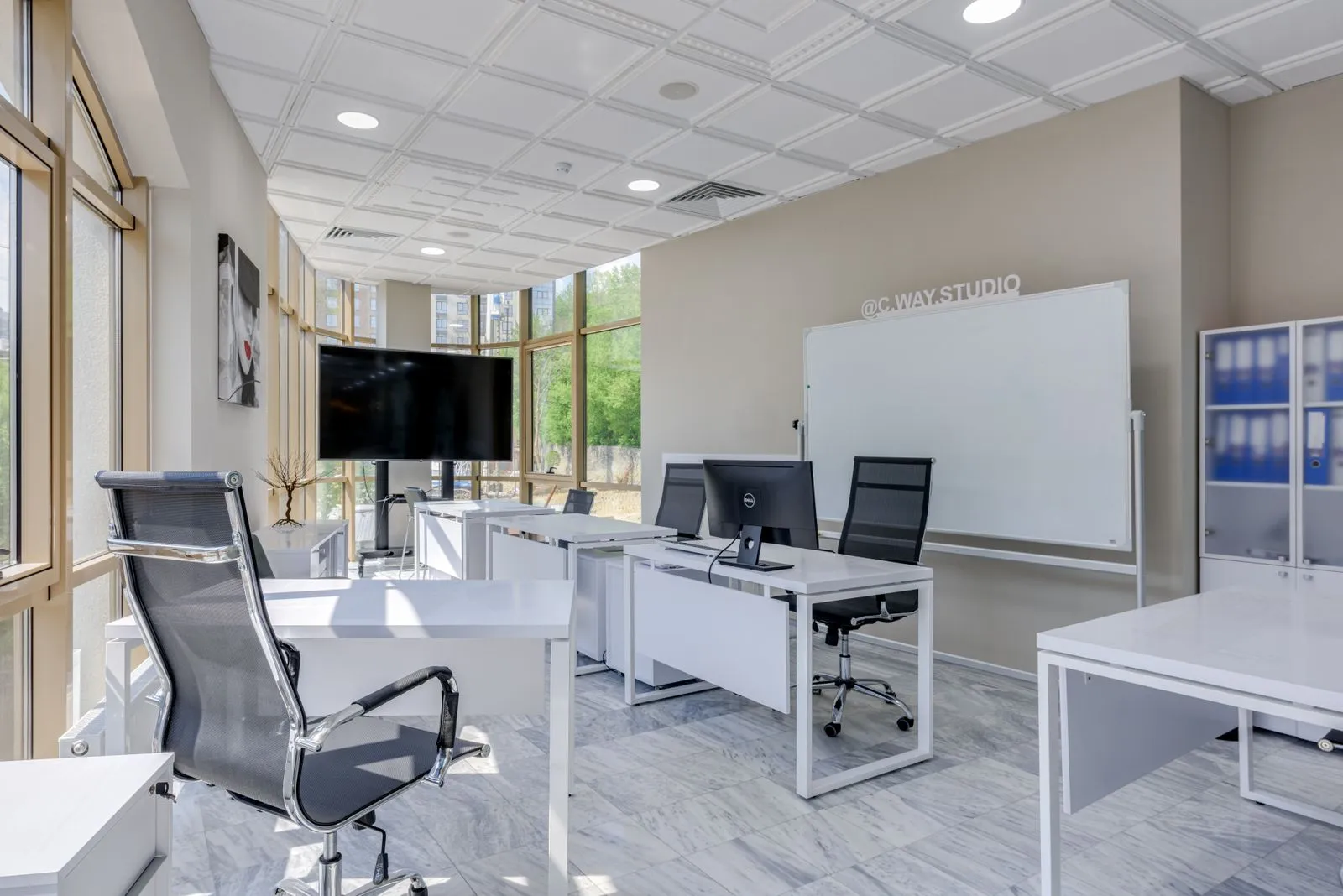 Adjustable office chairs and desks in a bright shared office