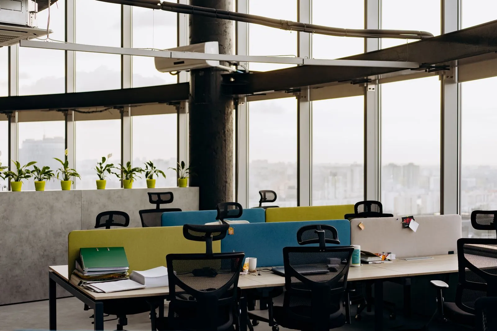 Office desks with monitors, mesh chairs and colourful partitions
