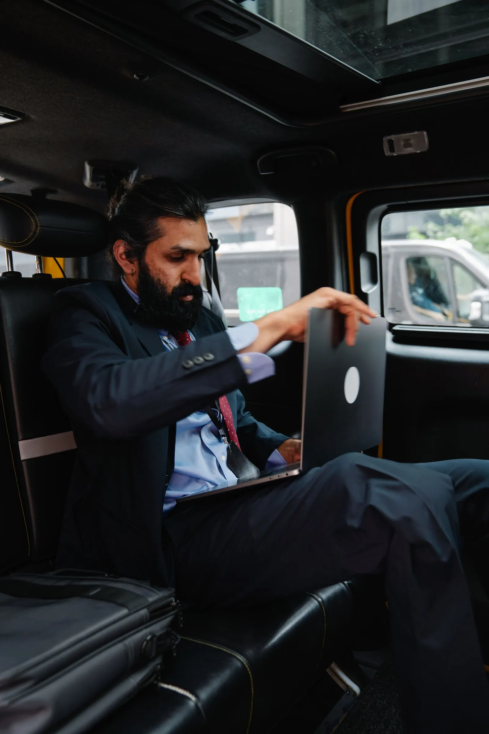 A person using a laptop in a car seat